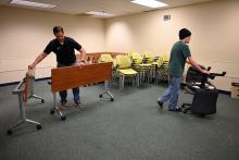 Facilities staff member and volunteer moving classroom furniture. 